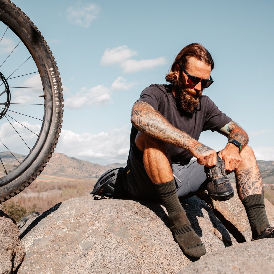 Mountain biker seated on rock wearing Element crew mountain bike socks