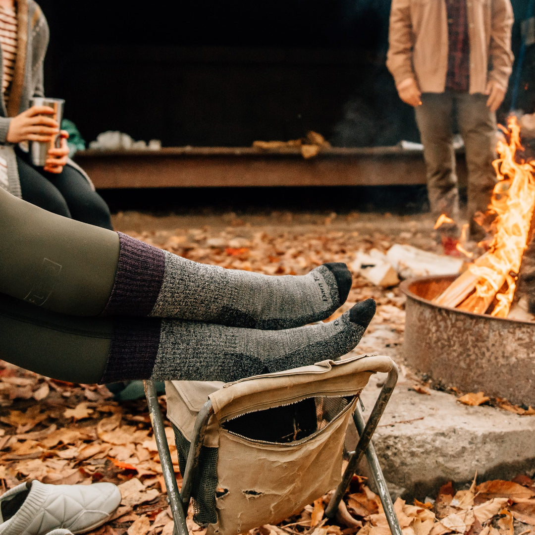 Hikers out in fall weather wearing merino wool boot socks by a fireplace