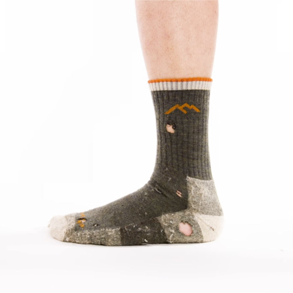 A foot wearing a Darn Tough sock that needs to be warrantied - it has some holes and rips