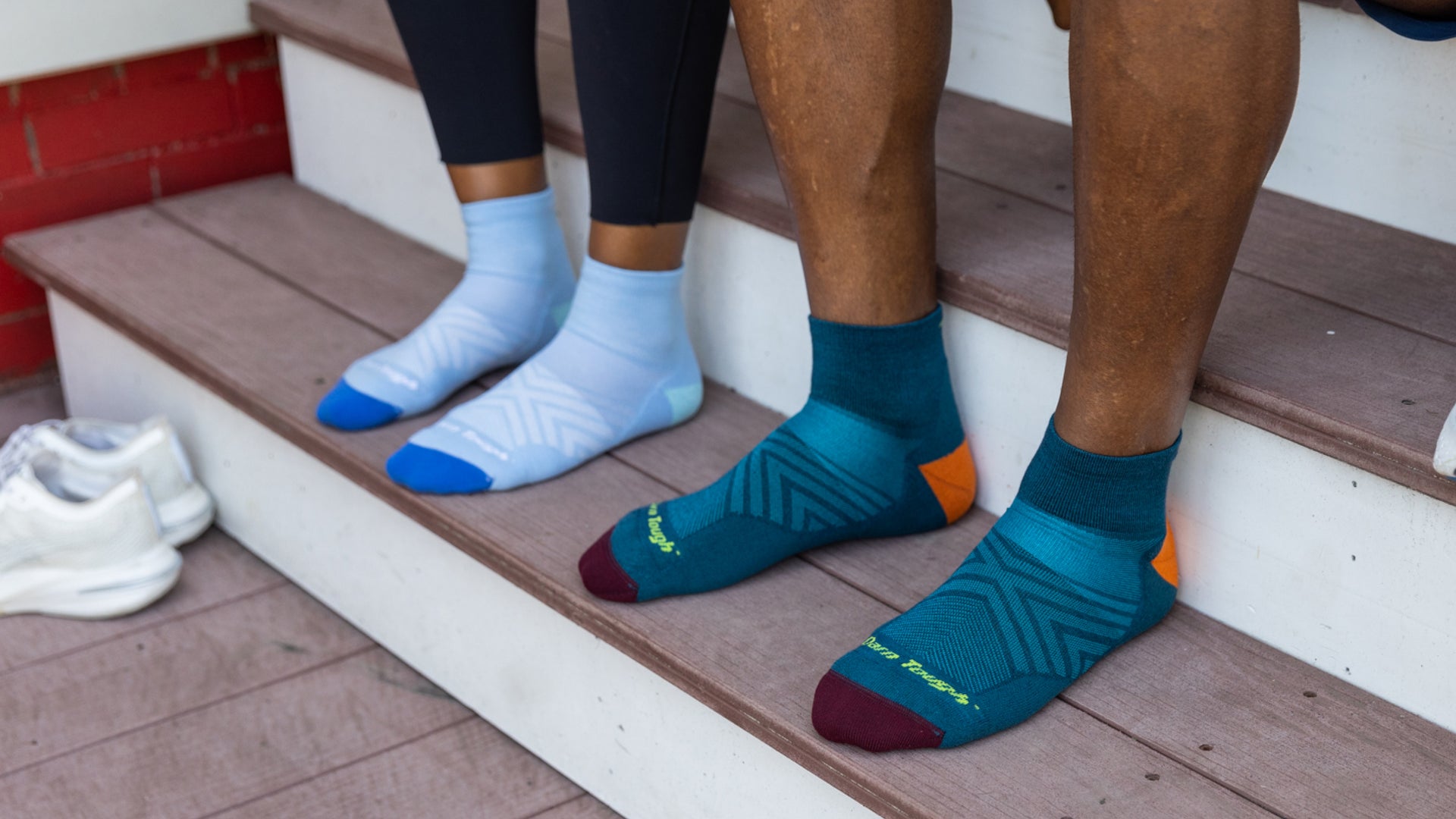 Men's and Women's Ultra-Lightweight Quarter running socks featured on Model on a set of stairs.