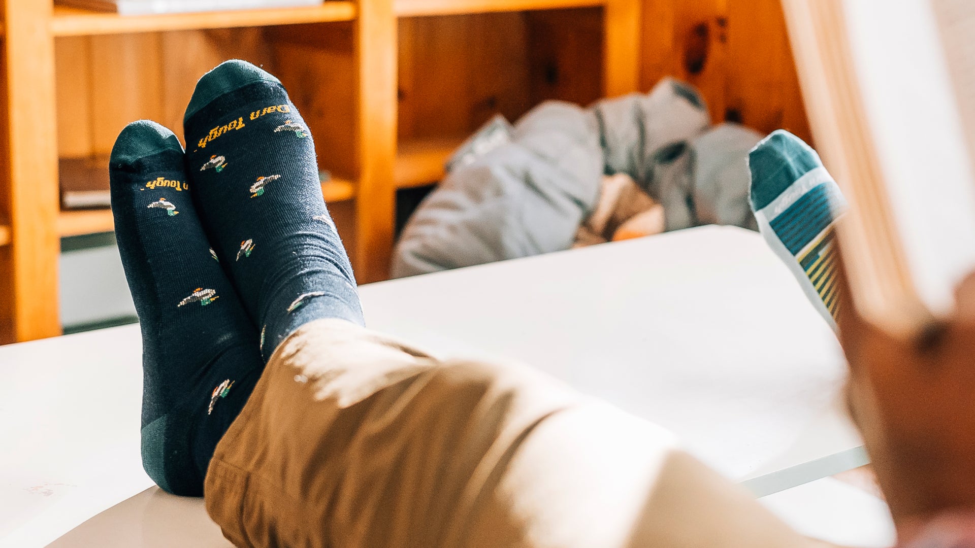 Model with feet up crossed wearing the duck duck moose sock