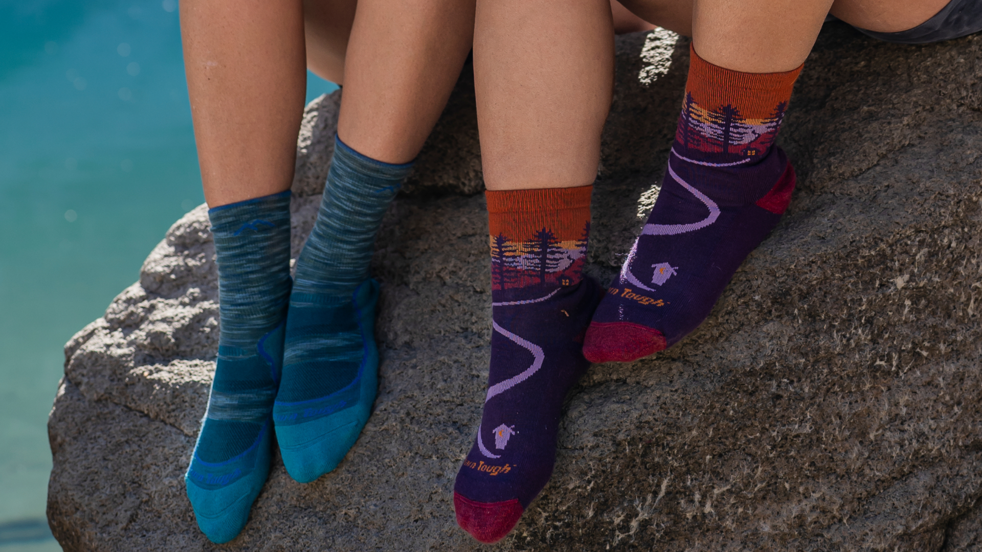 Two models feet on a rock wearing the Northwoods micro crew in nightshade and cascade light hiker