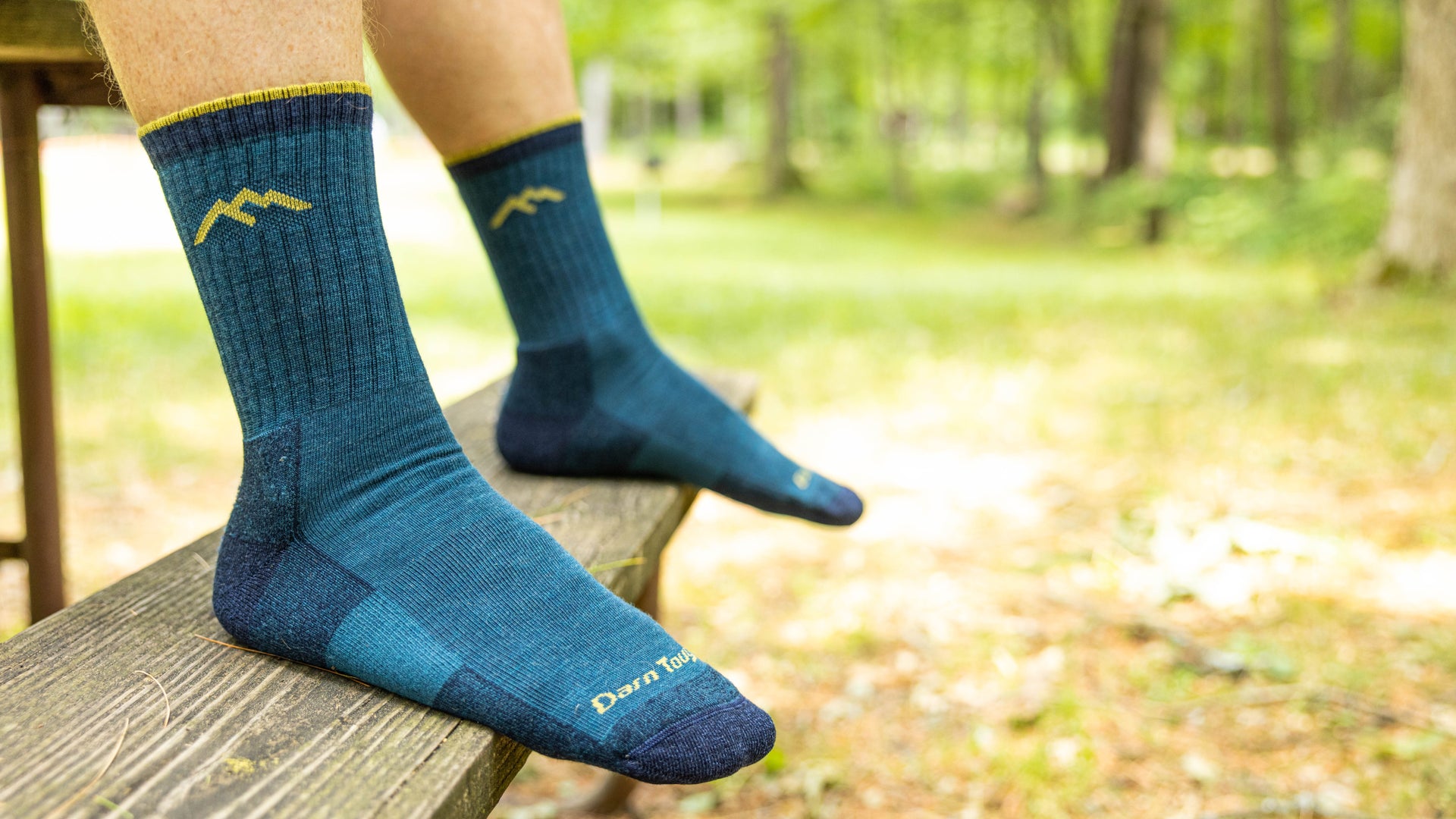 Model resting feet on bench wearing the 1466 in Dark teal