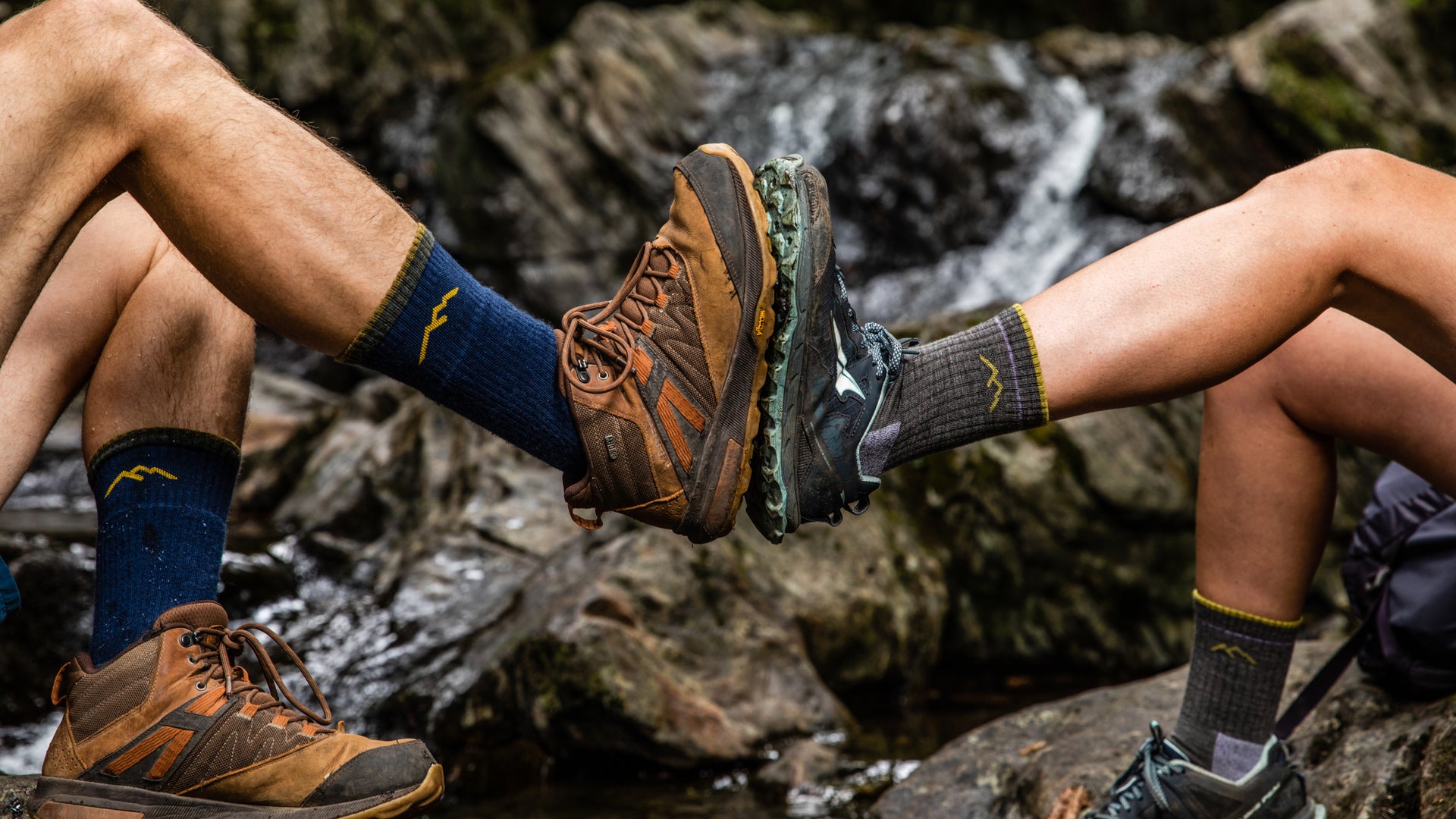 Models holding feet up together to feature the men's 1403 midweight boot sock and the women's 1903 midweight micro crew sock.