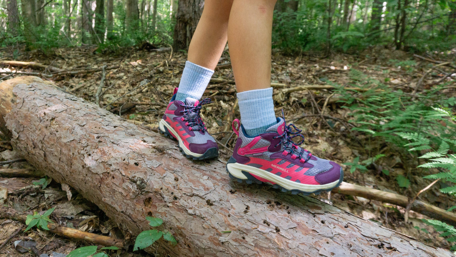 kid walking on log in sneakers wearing the hill topper micro crew hiking sock