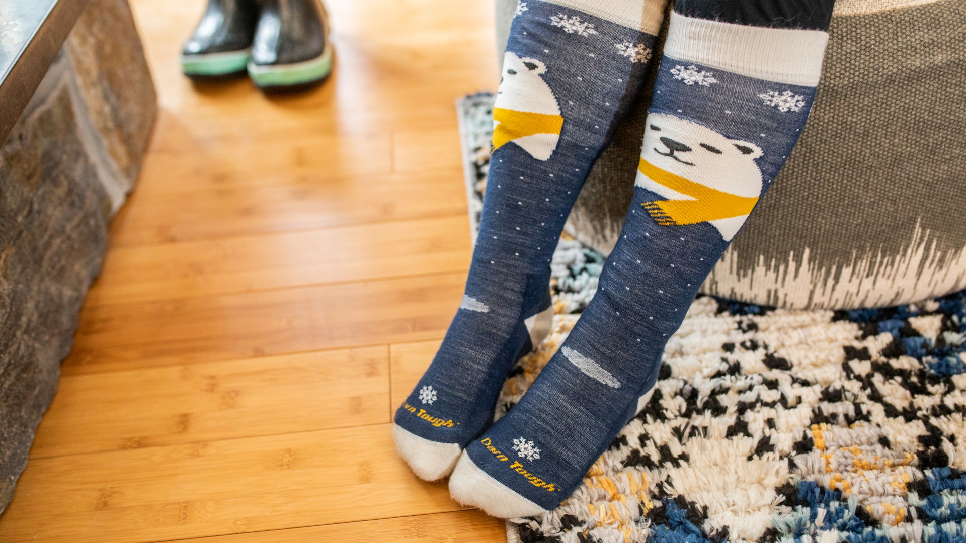 Up close image of models feet on hardwood floor wearing the Polar bear Ski and snow socks