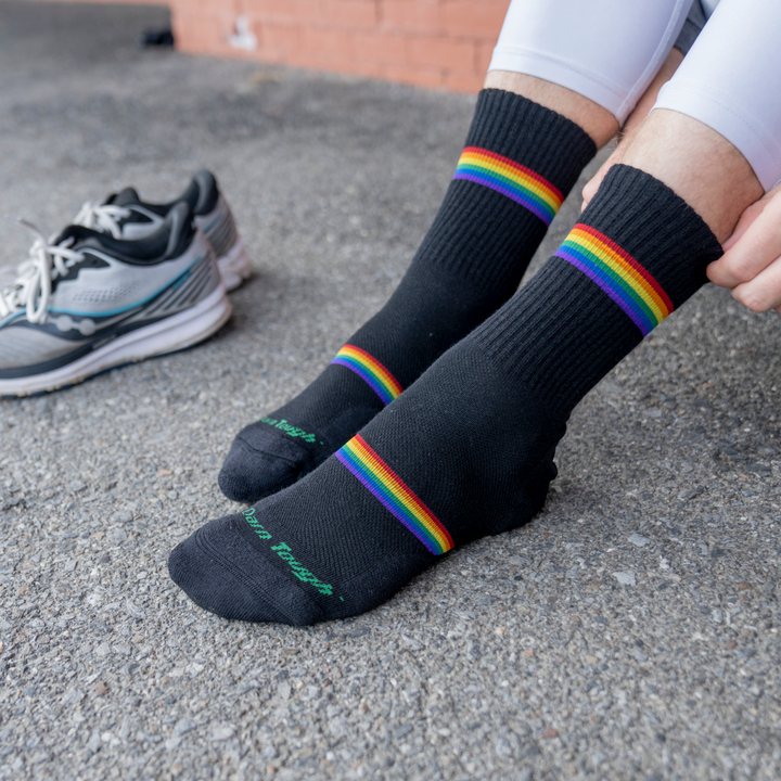 model image of feet on the pavement wearing the 1119 Prism in black with sneakers in the background