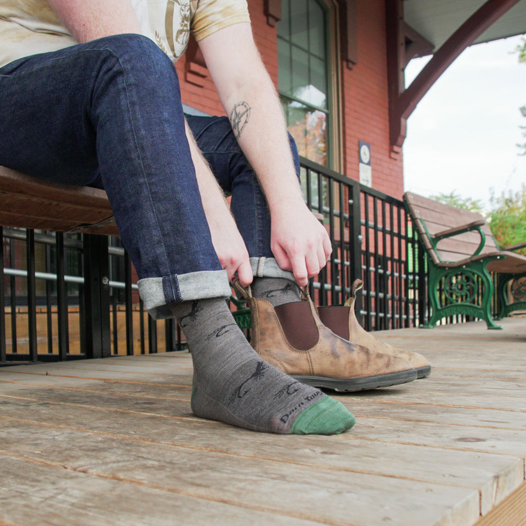 model pulling on shoe of back foot and front foot wearing the 1671 taupe