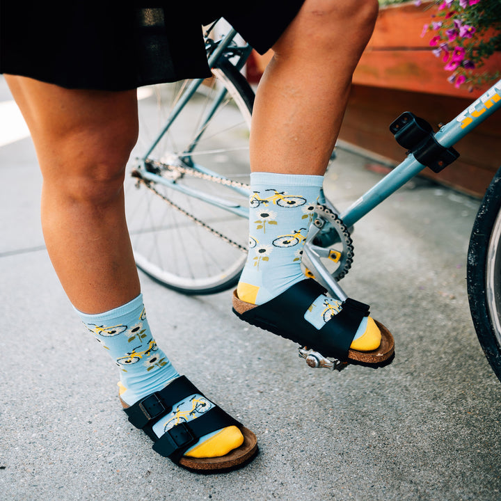 Close up shot of model wearing the women's sun pedal crew lifestyle socks in glacier blue with black birkenstocks