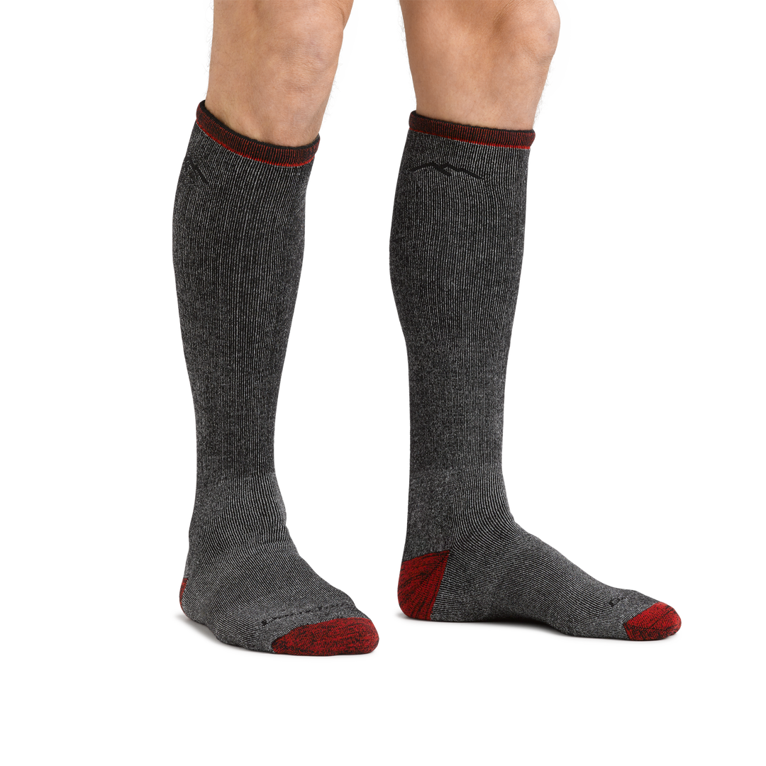 Man standing barefoot wearing Mountaineering Over the Calf Heavyweight Hiking Sock in Smoke