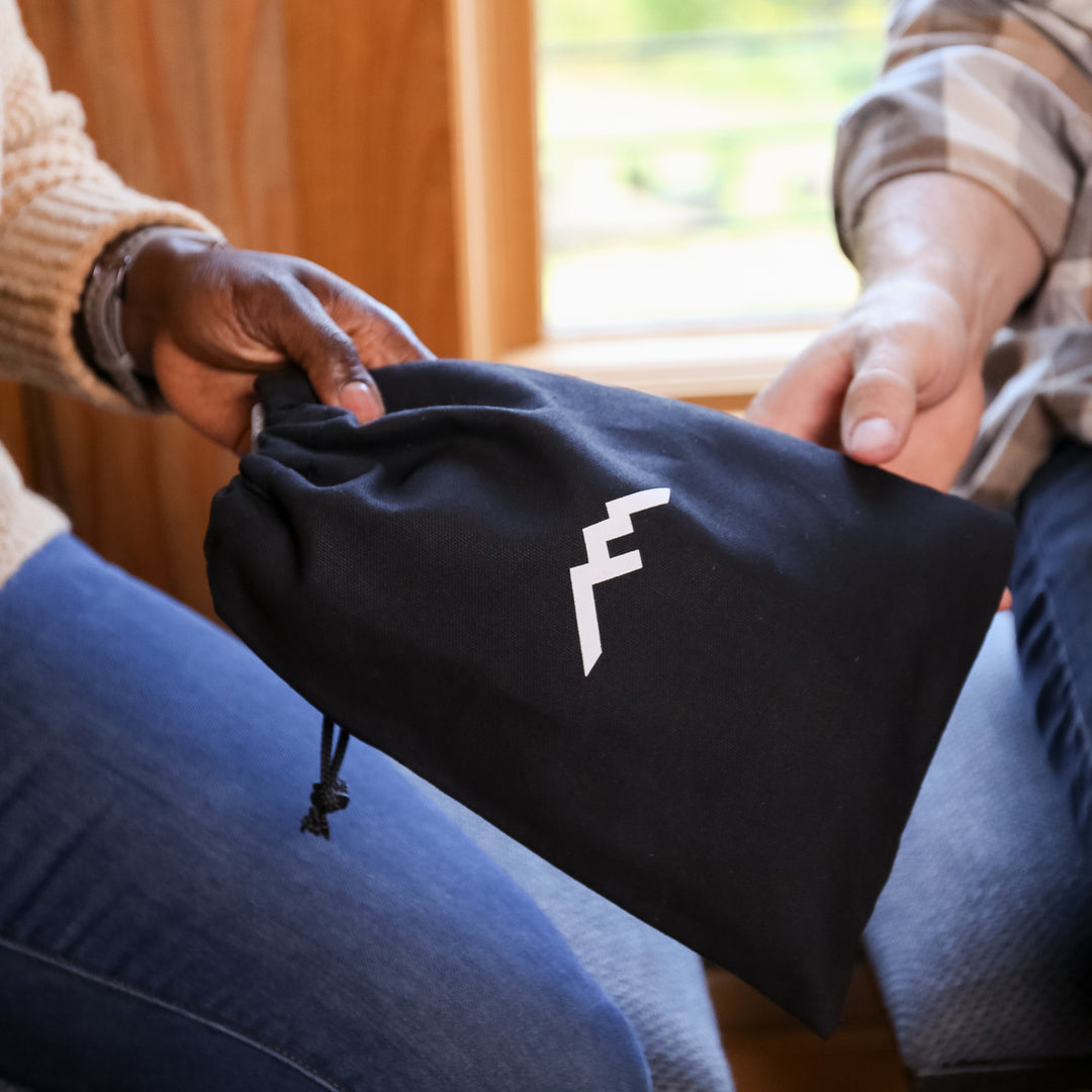 Close up image of gift bag being handed from one model to another