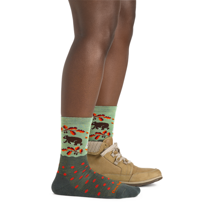 Side shot of model wearing the women's wild life crew lifestyle socks in forest with a tan boot on her left foot