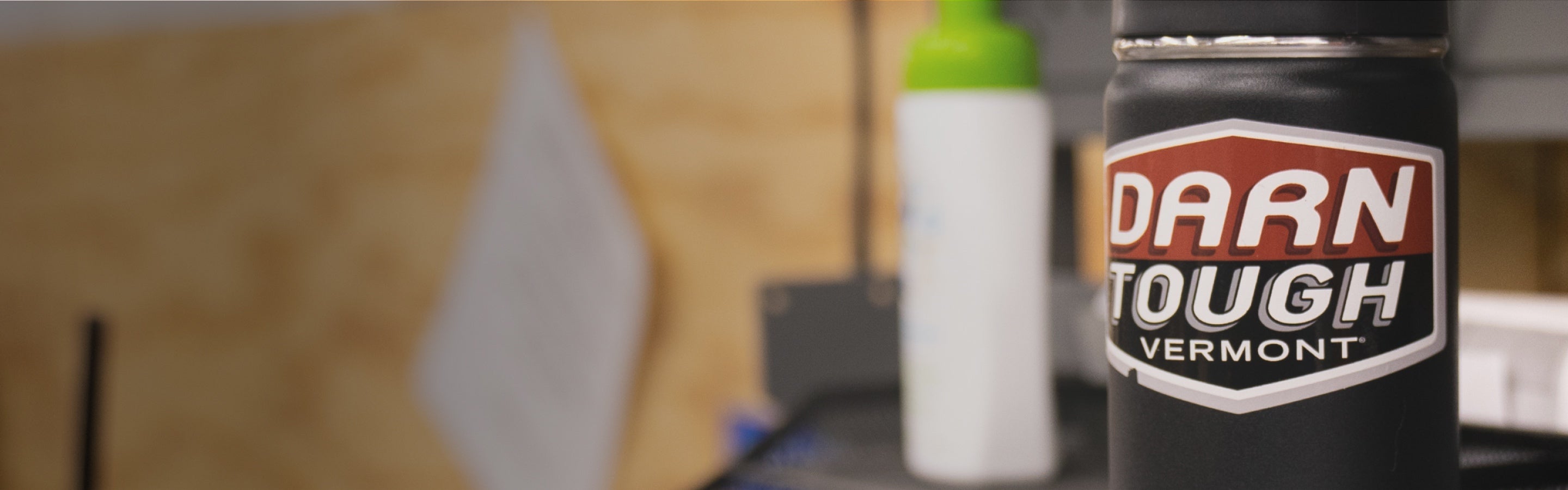 View from a darn tough desk with a water bottle bearing the Darn Tough logo on a sticker