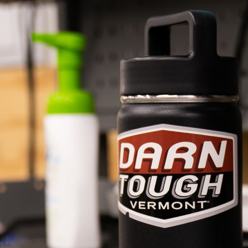 View from a darn tough desk with a water bottle bearing the Darn Tough logo on a sticker