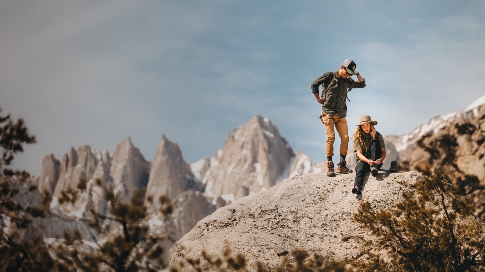Two hikers on the summit wearing darn tough socks for hiking