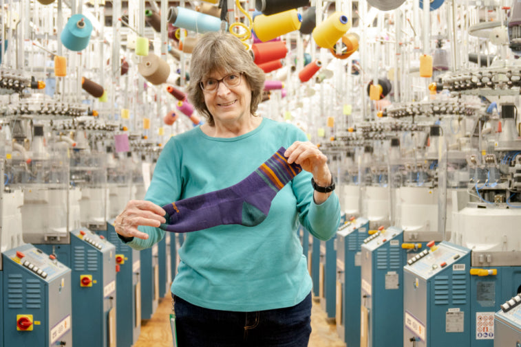Joan at the Mill holding out the Fastback sock, a micro crew with stripes