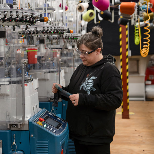A Darn Tough employee inspecting a pair of USA made socks