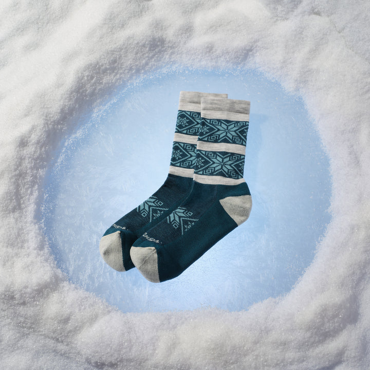 Pair of elsa crew socks laying on the ice spot in snow pile
