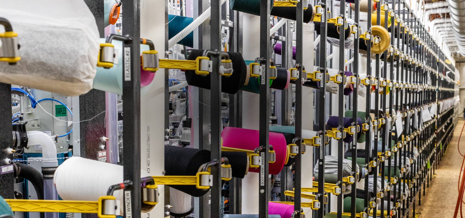 Rows of Merino Wool cones at the Mill where we knit our merino wool socks