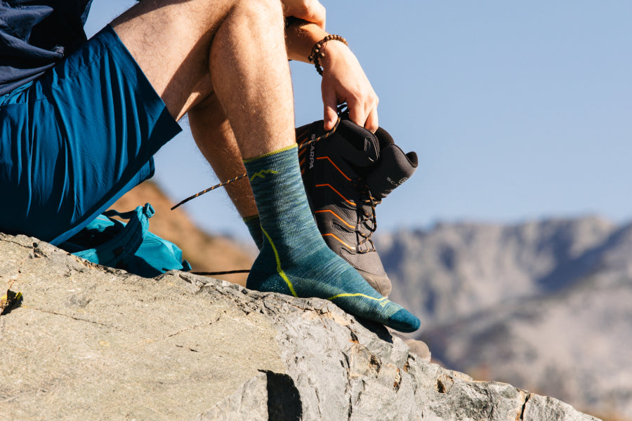 Hiker seated on mountain, shoes off, showing Light Hiker Micro Crew socks