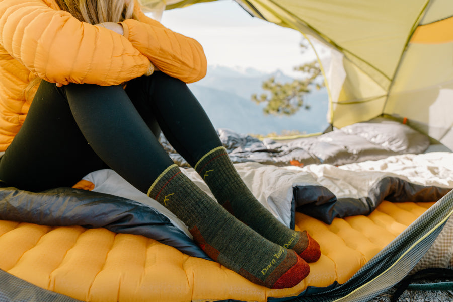 Person on sleeping pad wearing darn tough hiking socks