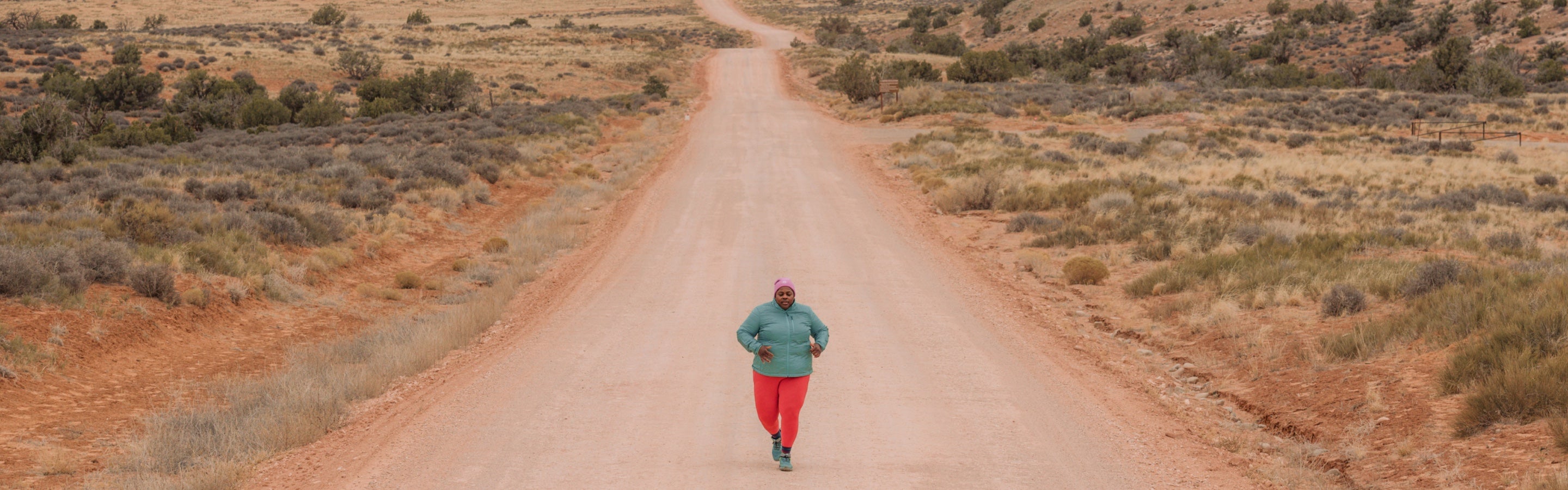 Mirna Valerio running down a dirt road out west wearing Darn Tough socks