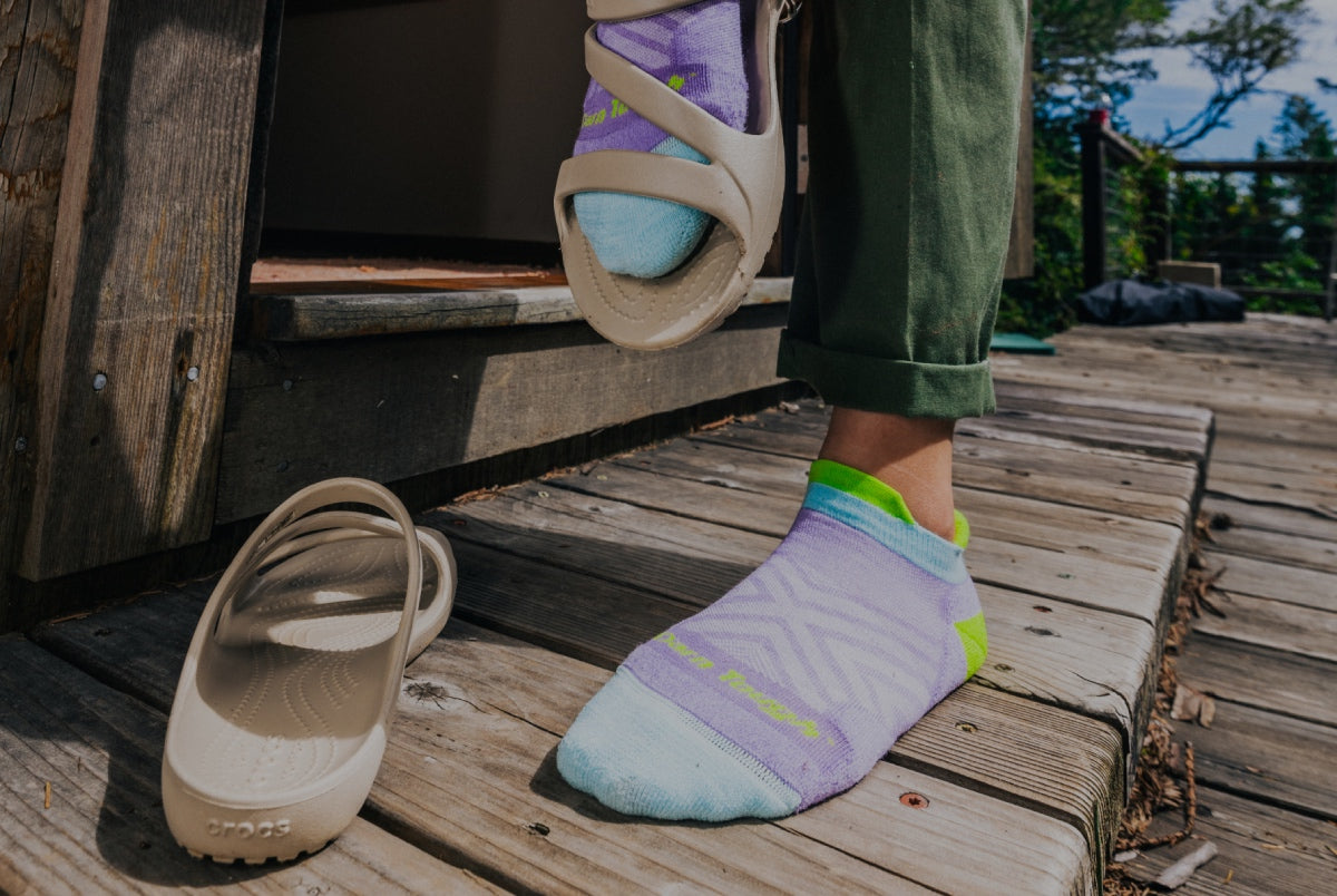 Shop Run Socks - a pair of feet wearing no show running socks in purple