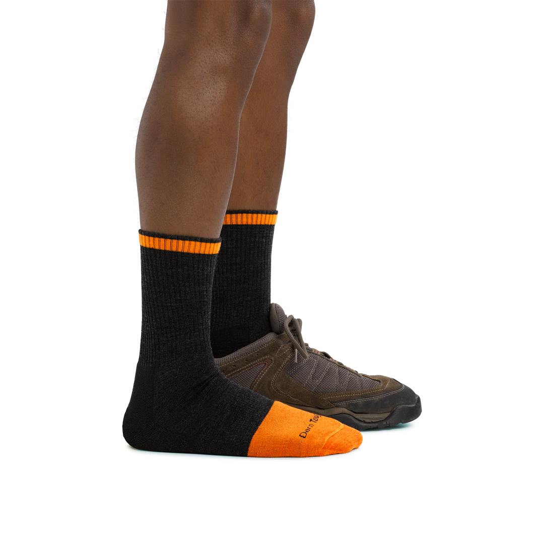 Man standing facing to the right wearing Steely Micro Crew Midweight Work Sock in Graphite and back foot in a shoe