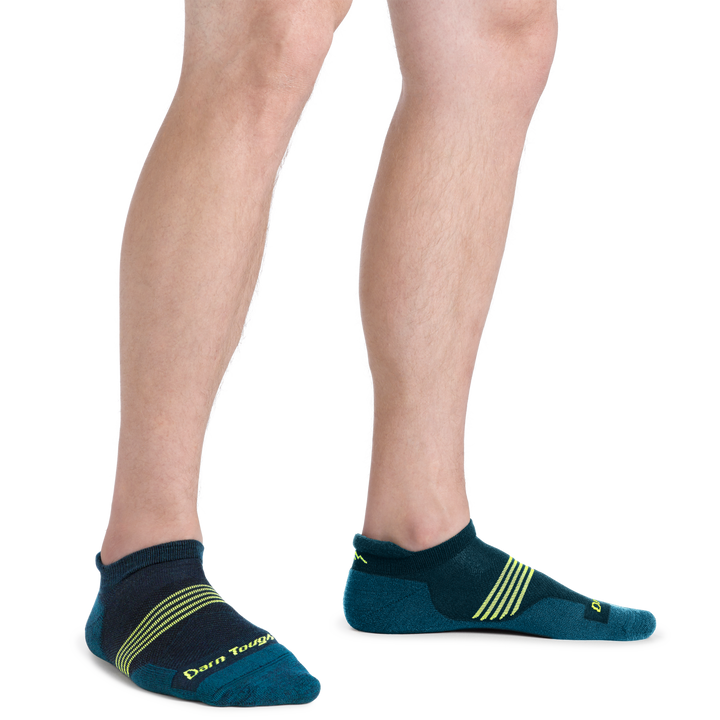 Man standing wearing Element No Show Tab Lightweight Running Sock in Blue with lime Green stripes on the forefoot