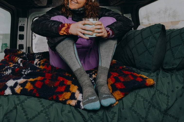 Shop Ski & Snowboard Socks - a person with a cup of cocoa wearing knee high ski socks