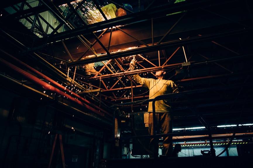 Industrial worker using a welder, sparks flying. Good thing merino wool is fire resistant