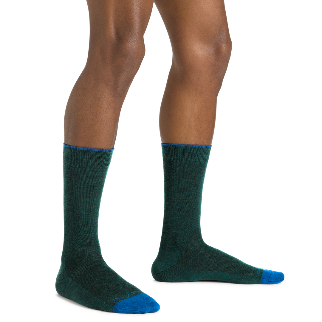 Model wearing the Men's Solid Crew Lightweight Lifestyle Sock in Bottle. Blue logo and accents on top of cuff and toe