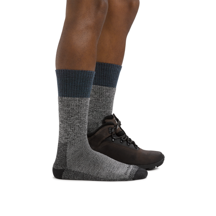 Profile of male legs facing right wearing Scout Boot Midweight Hiking Socks in Denim and a hiking boot on the foot in back
