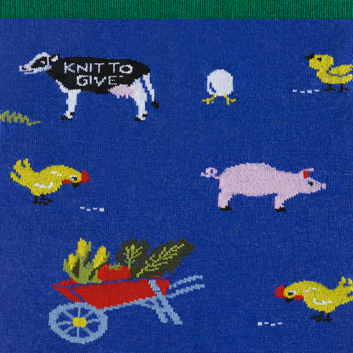 Barnyard crew sock close up featuring cow, pig, chicken, and 'knit to give' pattern