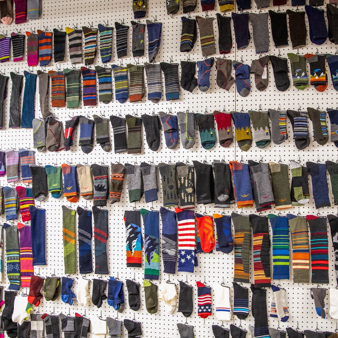 A wall completely covered in Darn Tough socks, dozens of different designs and colors