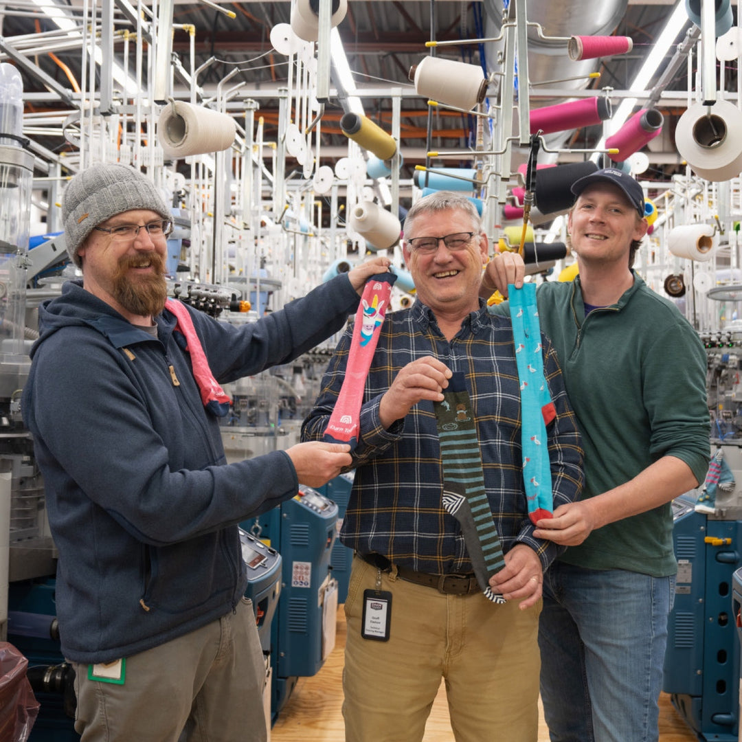 Two sons and their dad at Darn Tough mill, showing Father's Day gift ideas