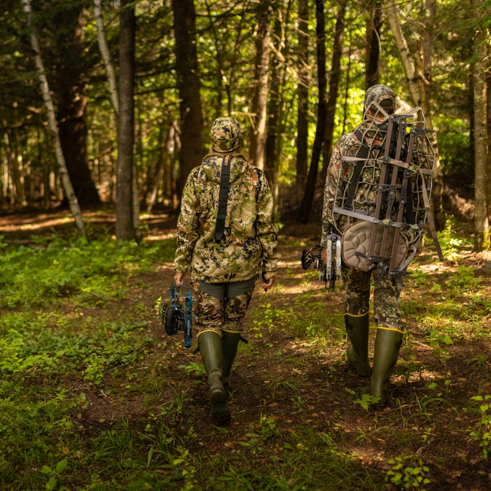 Two hunters walking down a trail in camo and darn tough hunting socks