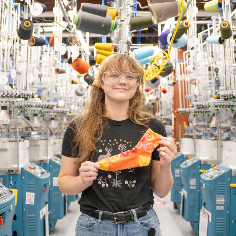 A Darn Tough employee holding up her favorite underrated sock - the Fruit Stand