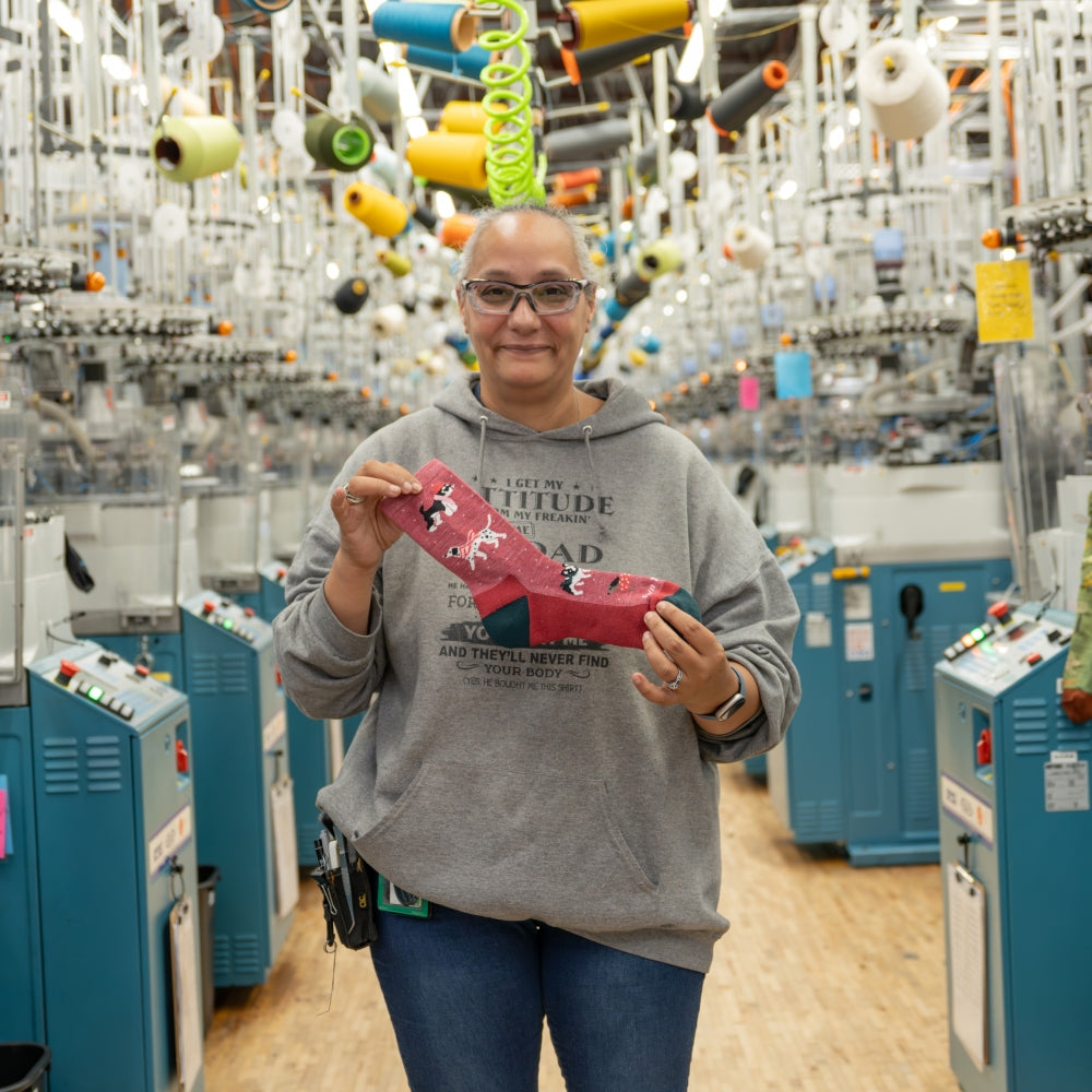 A Darn Tough employee holding up their 2024 sock gift recommendation