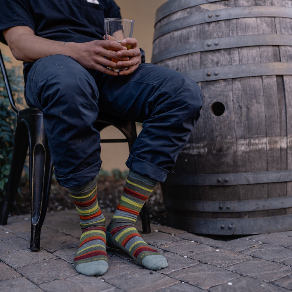 Feet wearing striped dress socks, the person looking concerned