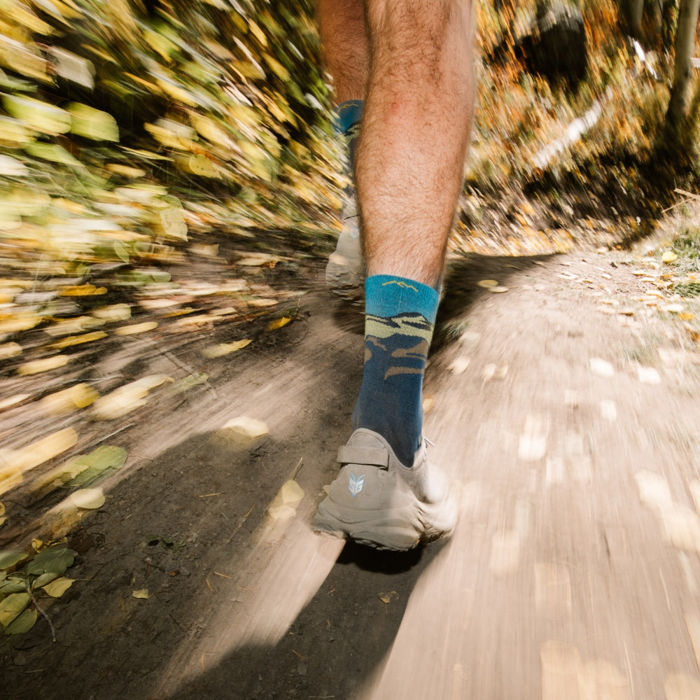 Feet in performance socks heading down a trail