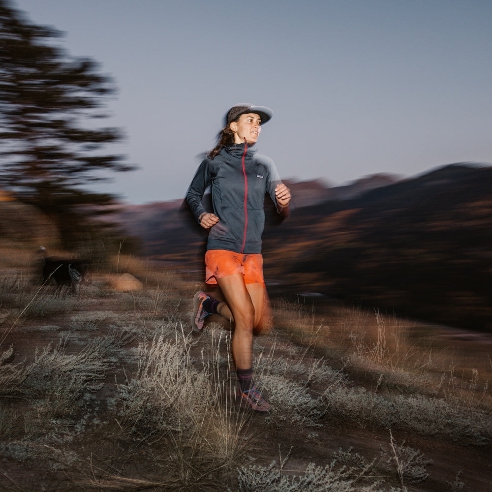 A woman out trail running in the very early morning