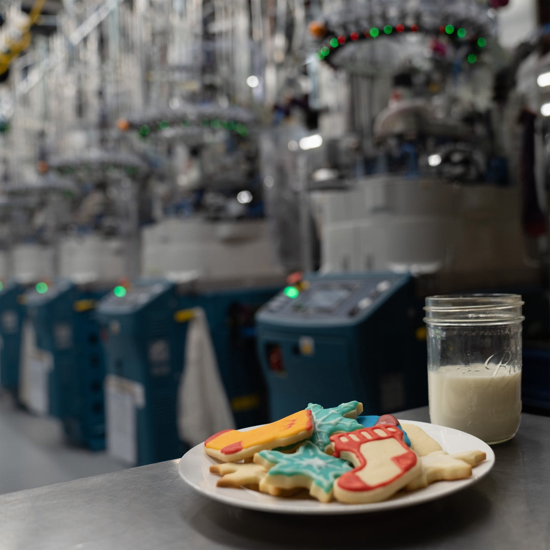 A plate of sock-shaped Christmas cookies and glass of milk left out at Darn Tough's Mill