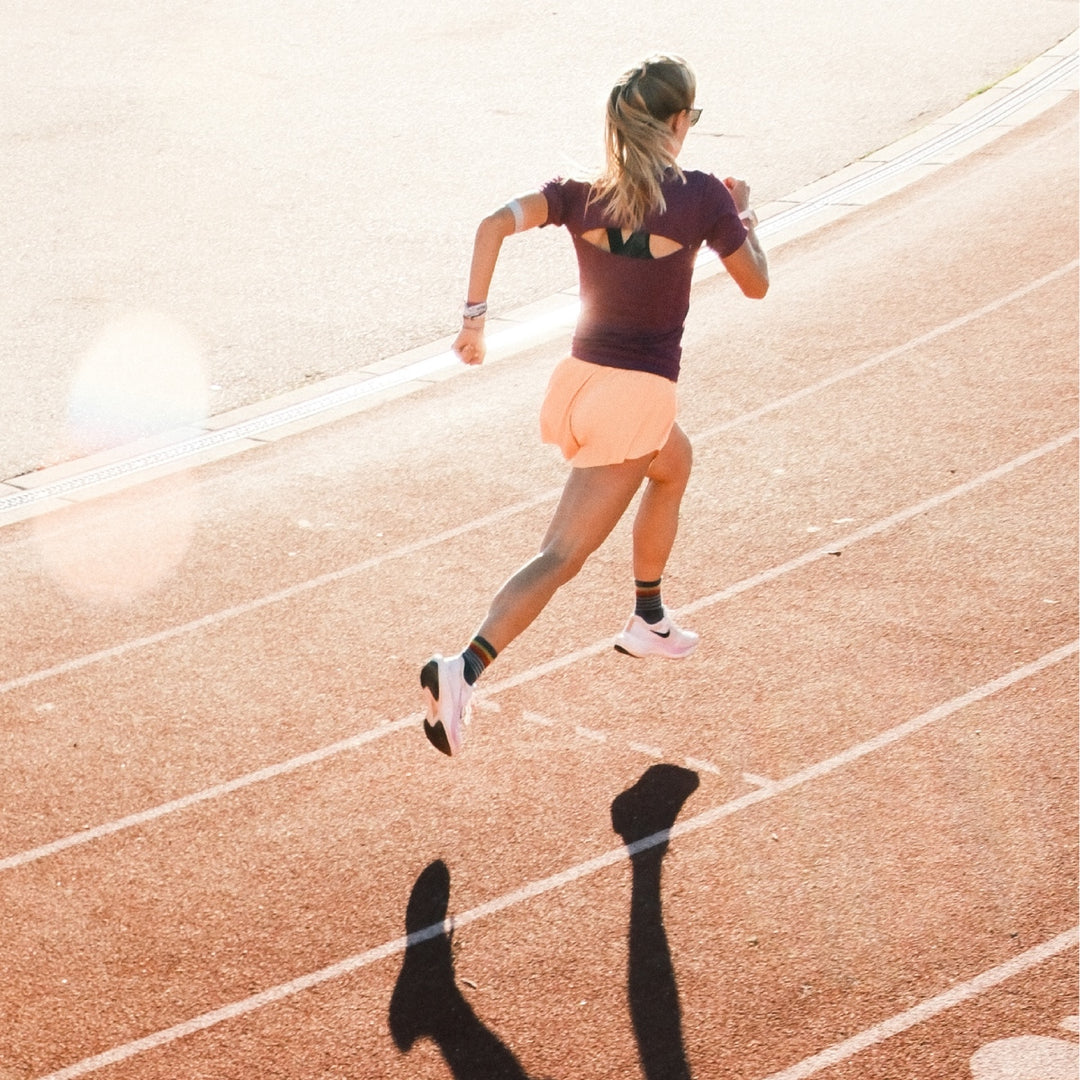 Bailey Kowalczyk running down the track wearing Darn Tough running socks