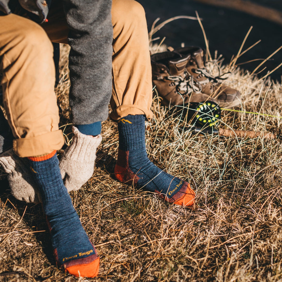a man pulling on darn tough hiking socks, a great gift for dad