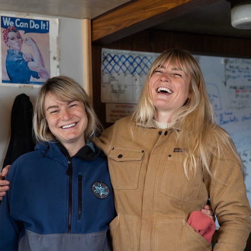 The Salmon Sisters, Emma and Claire, smiling and laughing while hugging each other