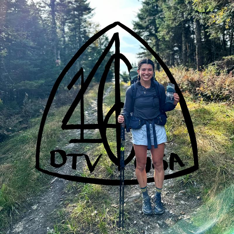 A happy hiker holding up a free pair of socks from 1466 Day