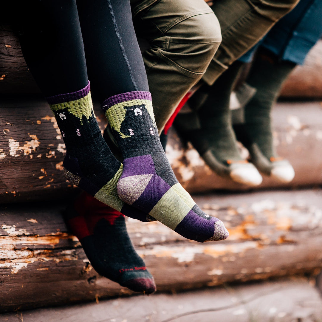 Feet wearing the fun bear town socks with bears on them in purple and green