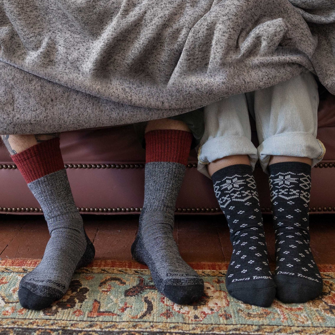 Two people on couch under a blanket with sock-clad feet sticking out wearing the most comfortable socks