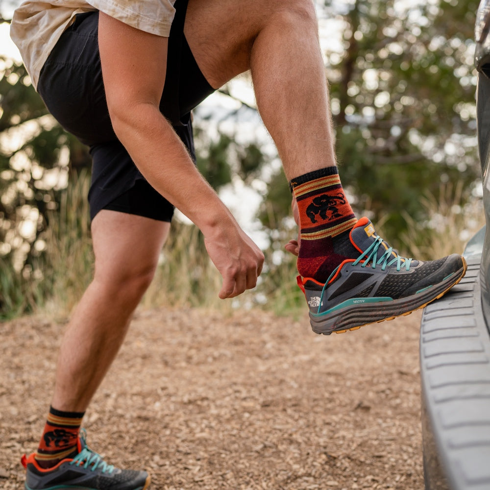 Person at trailhead putting on hiking shoes and merino wool socks to prevent blisters